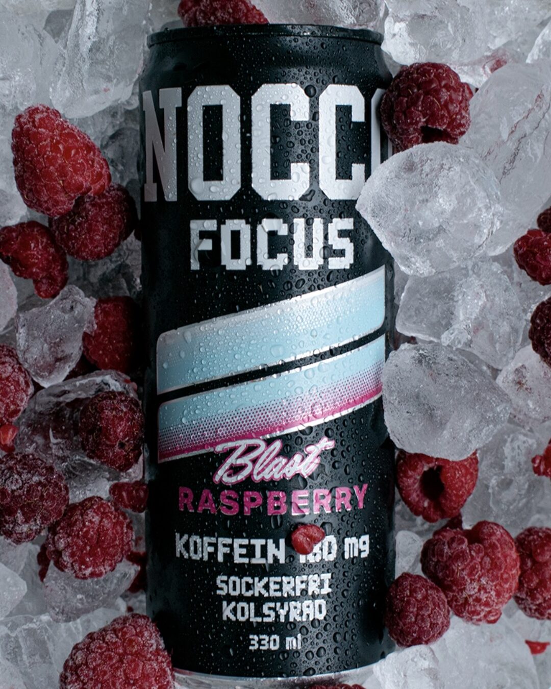Nocco Fokus Raspberry blast mot bakgrund av is och hallon.